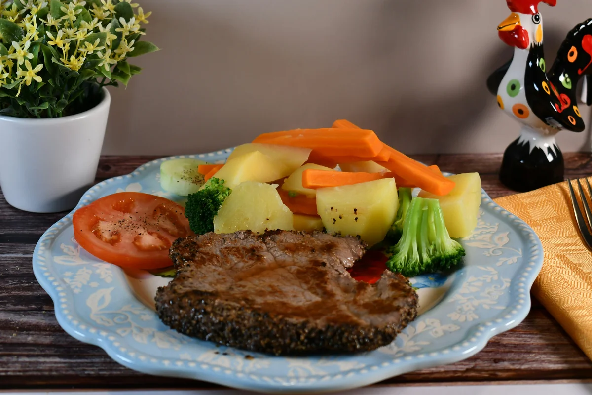 Steak with boiled potatoes, carrots, broccoli, and tomato - balanced meals
