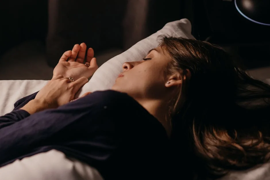 A woman sleeping comfortably on a pillow in a softly lit bedroom, capturing a peaceful nighttime ambiance. - dream analysis experts online