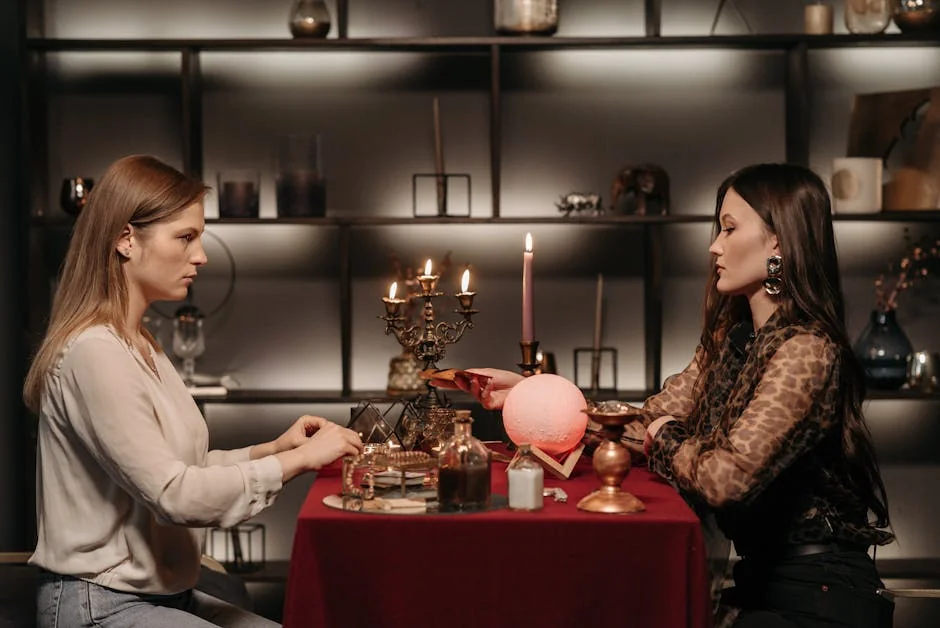 Two women engaged in fortune telling with a crystal ball in a mystical indoor setting. - keen psychic reviews
