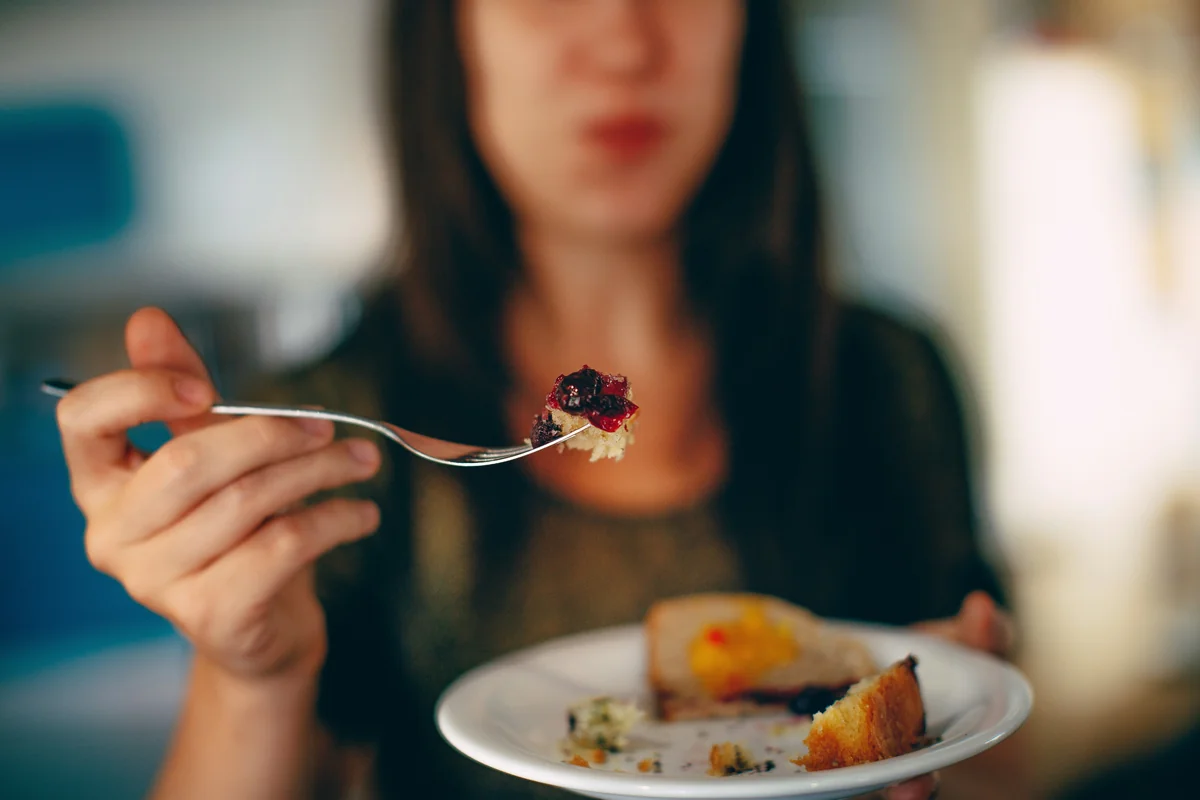 woman holding plate of cake - mindful eating
