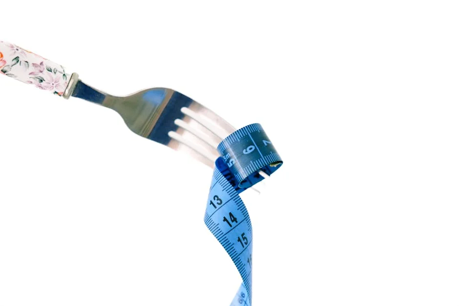 A fork twirls a blue measuring tape, symbolizing weight management and health. - portion control
