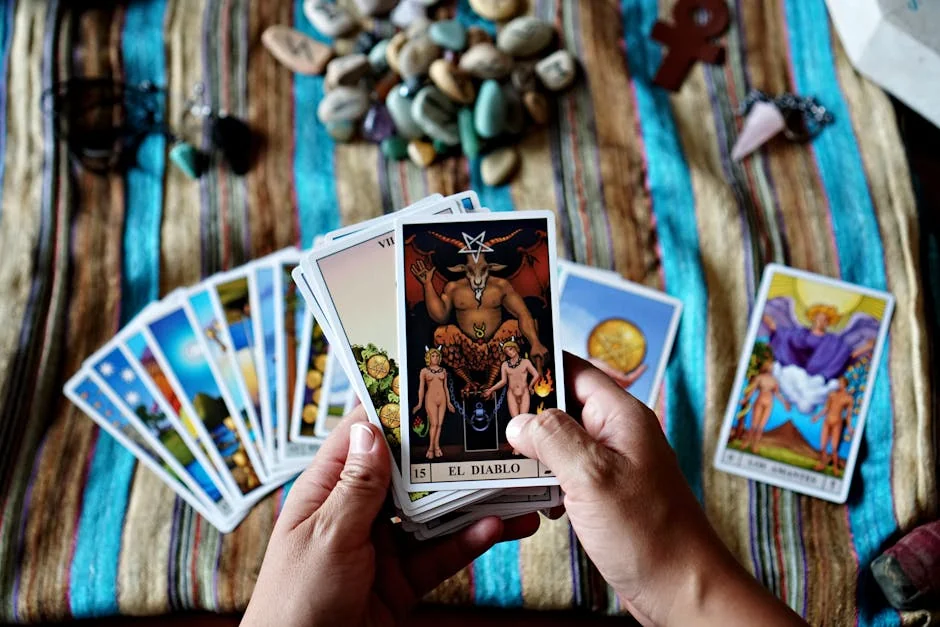 Hands holding tarot cards, focusing on 'El Diablo,' set on a colorful cloth background. Ideal for mysticism and fortune-telling themes. - trusted tarot readers online