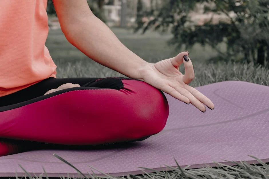 Close-up of a person meditating outdoors on a yoga mat, focusing on tranquility and mindfulness. - wellness tips